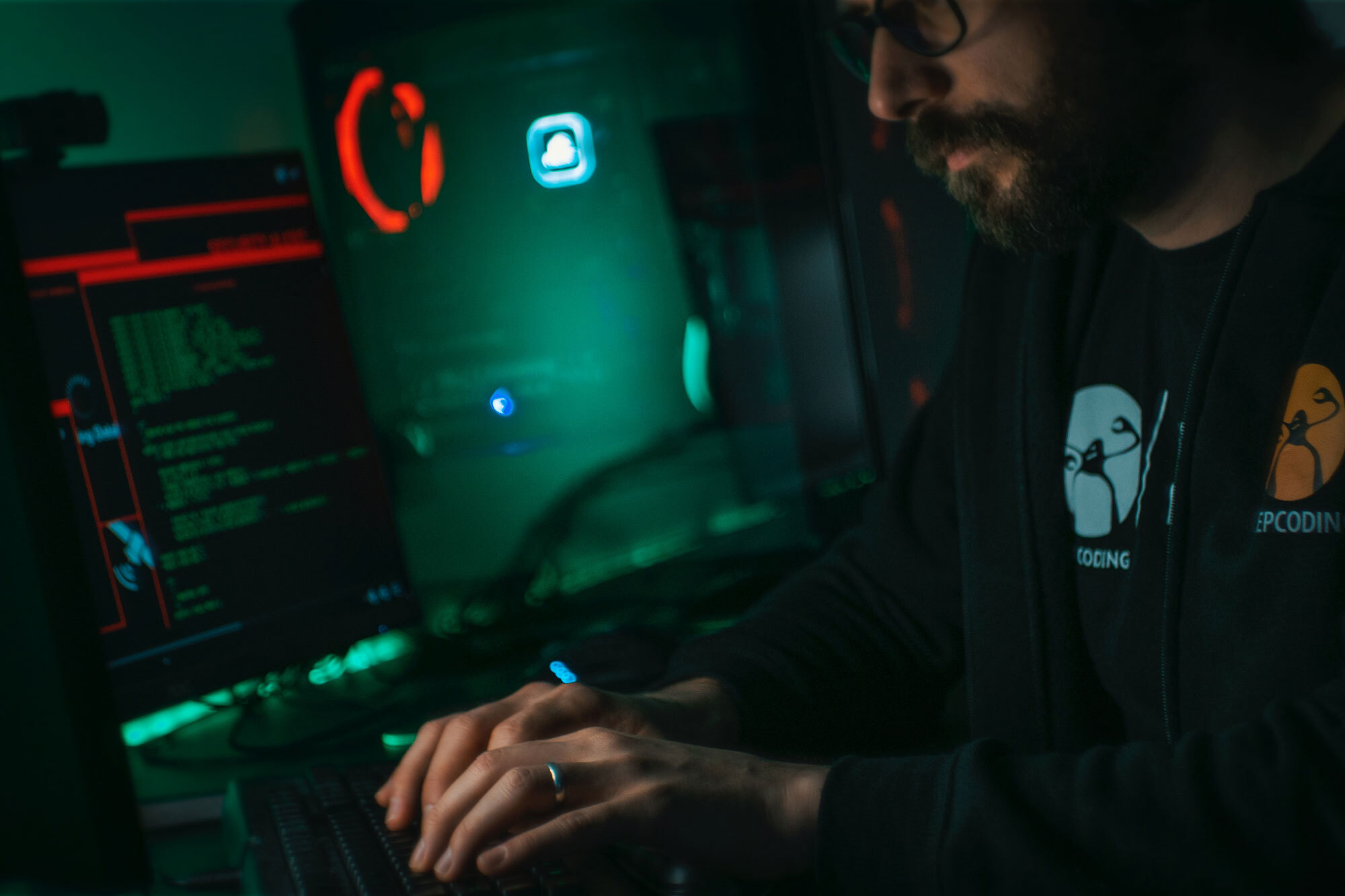 person in a dark room coding on a computer.