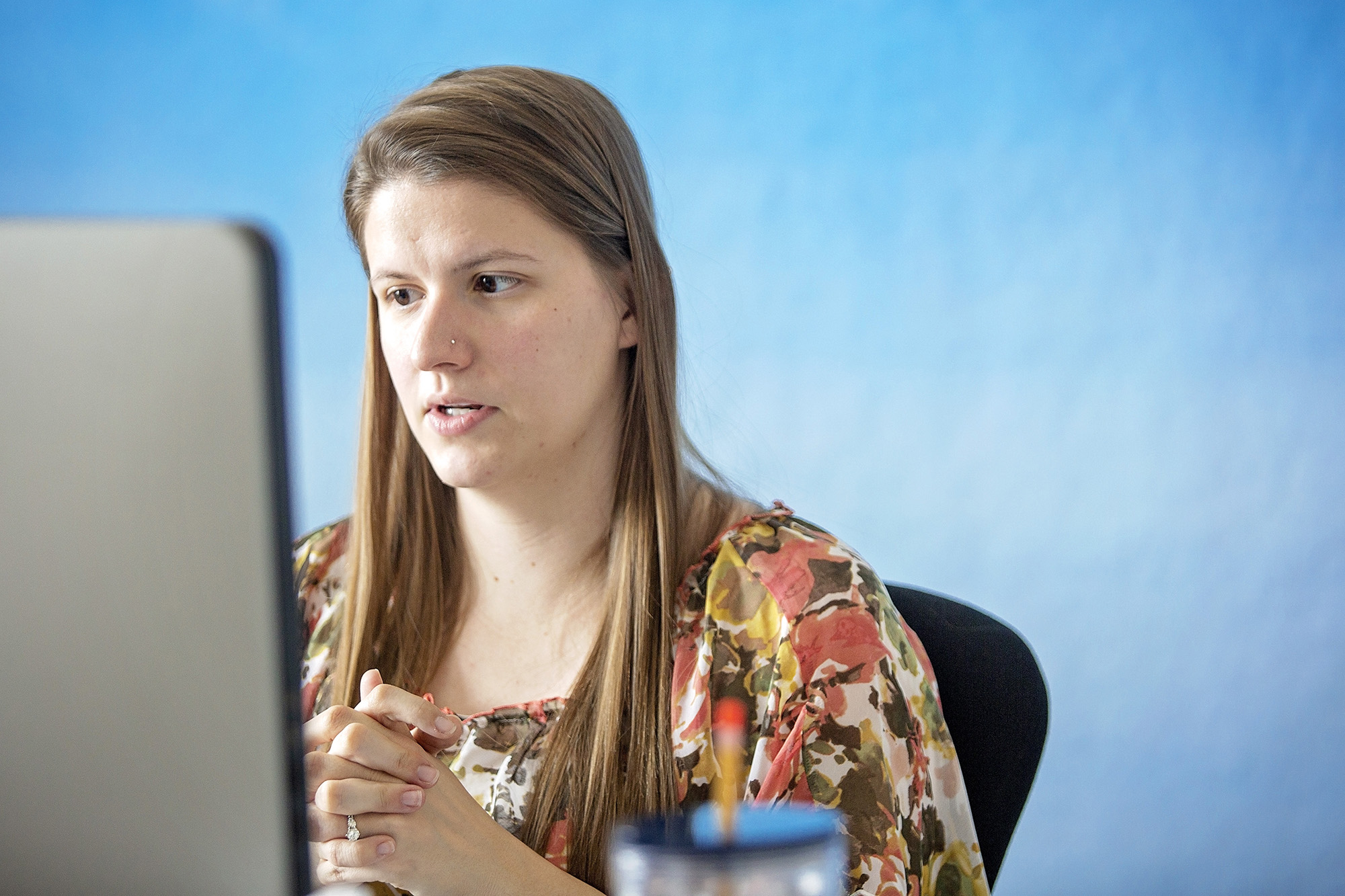 A staff member looks down at a computer screen.