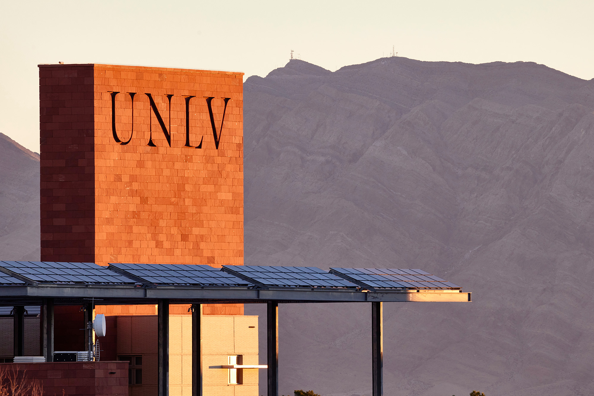 Sunrises on a building with UNLV carved into the side.