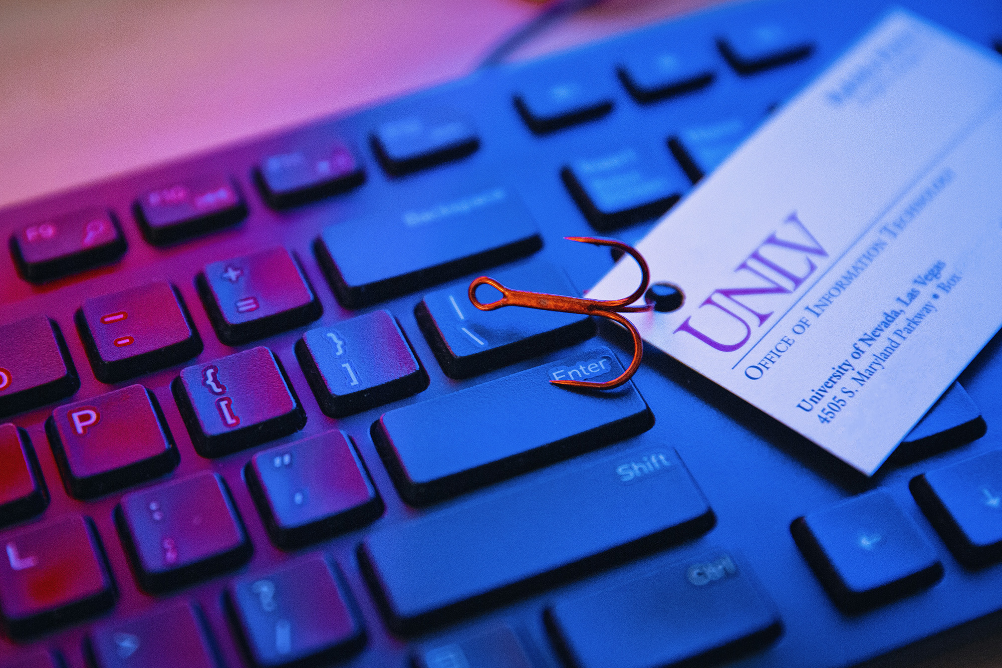 A keyboard with a fish hooked OIT business card