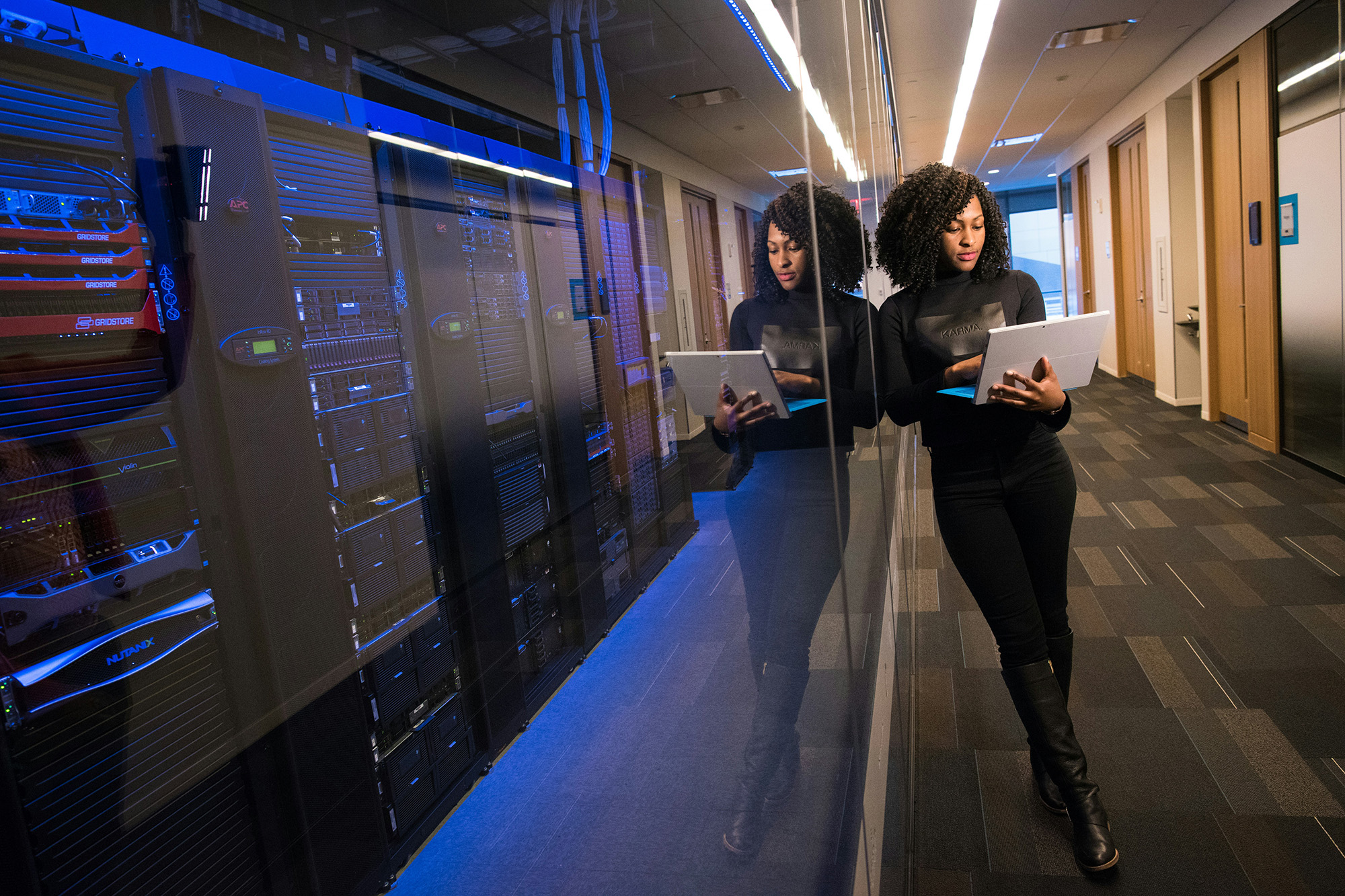 Woman outside of a server room using a Surface laptop