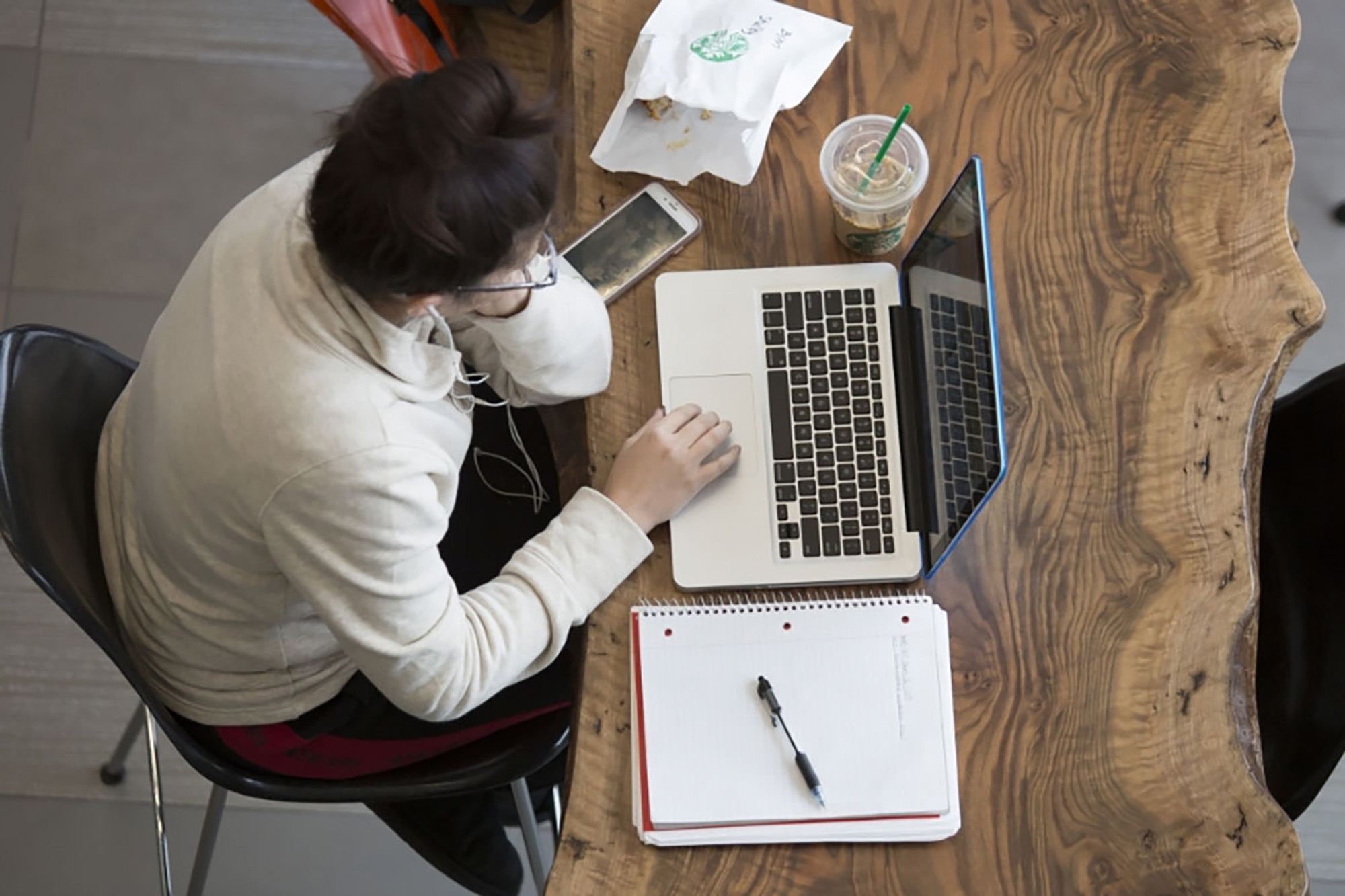 Aerial view of a male student studying on a laptop.