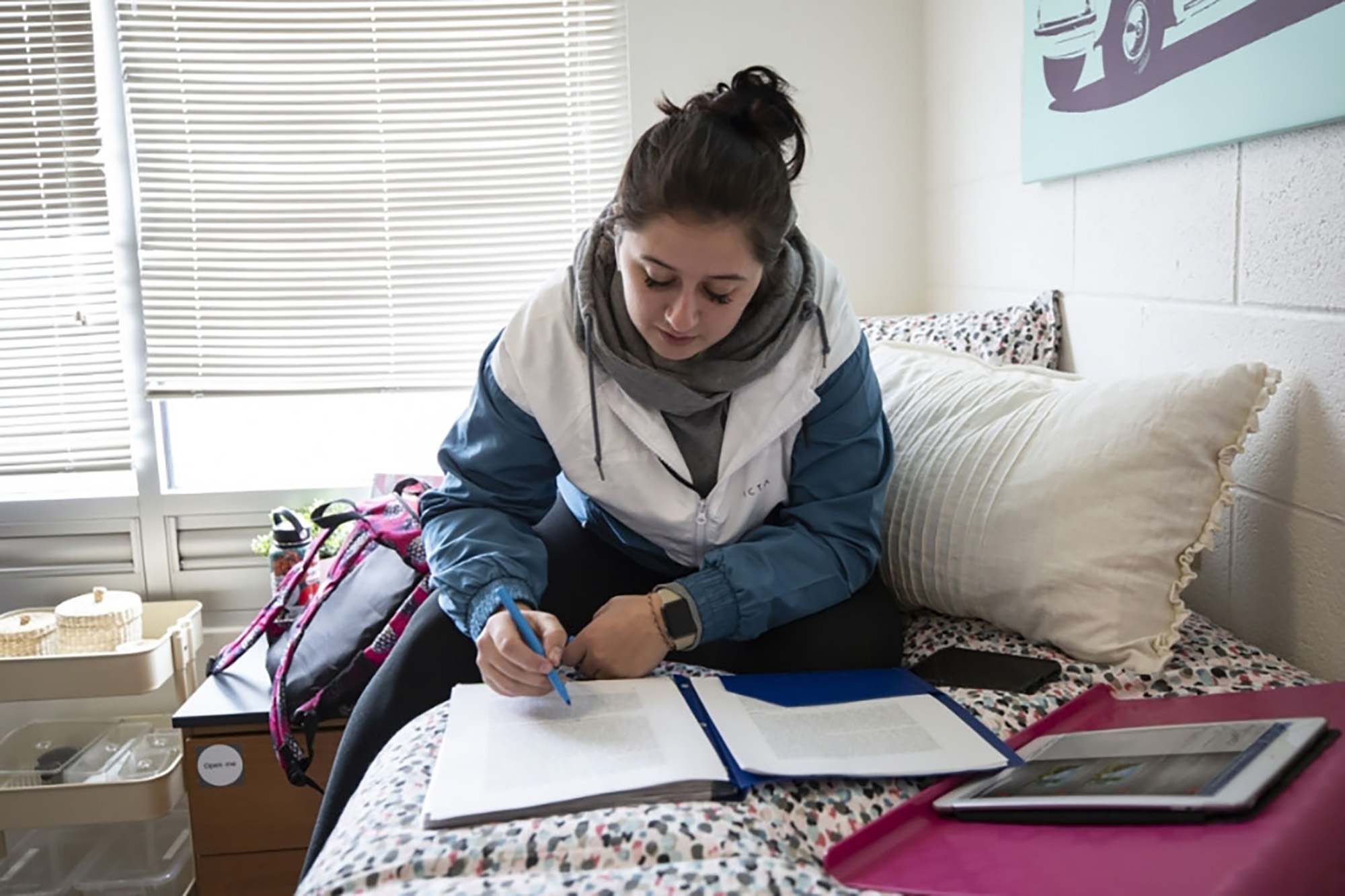 A female student studies in her dorm room.