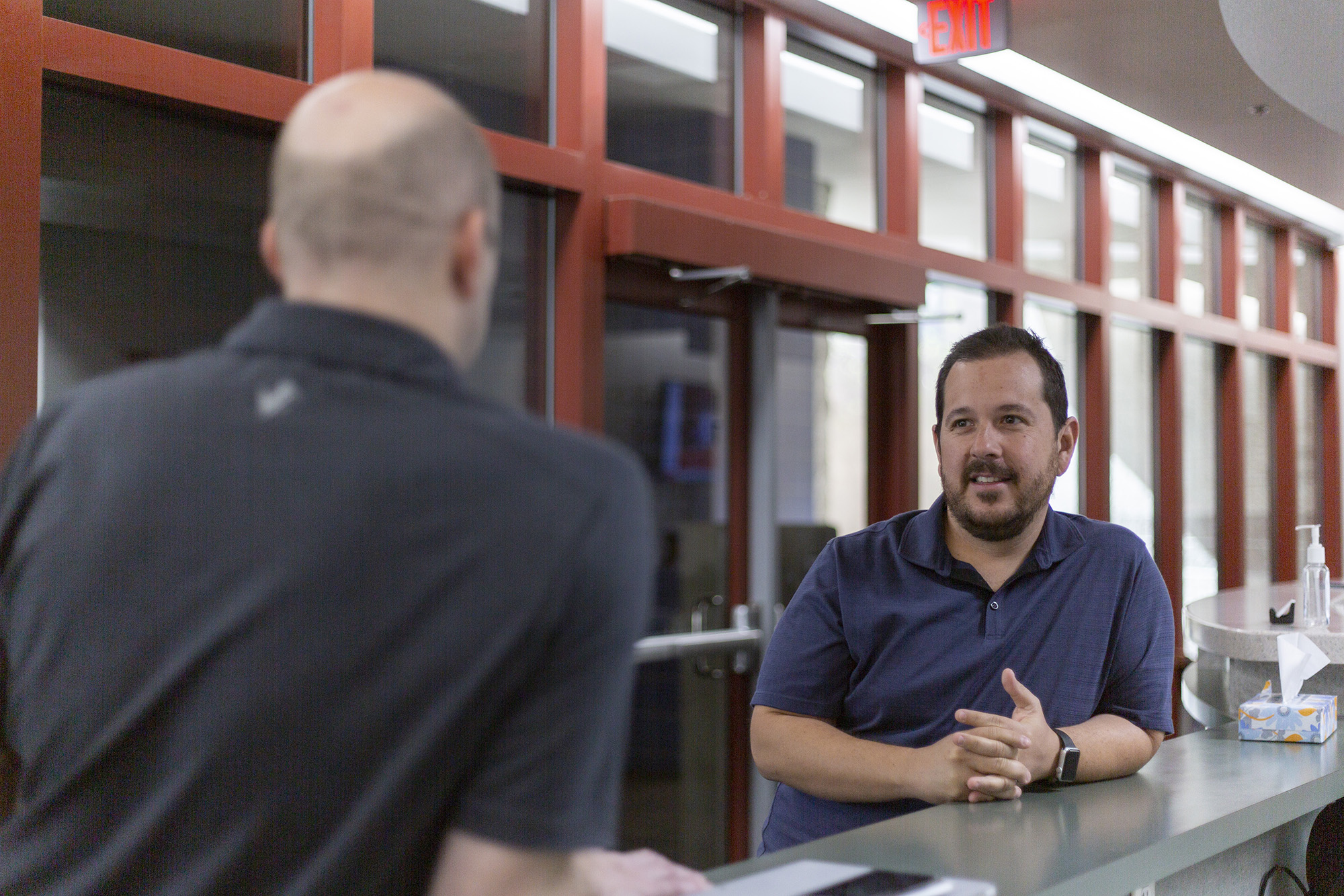 Two male staff members have a conversation.