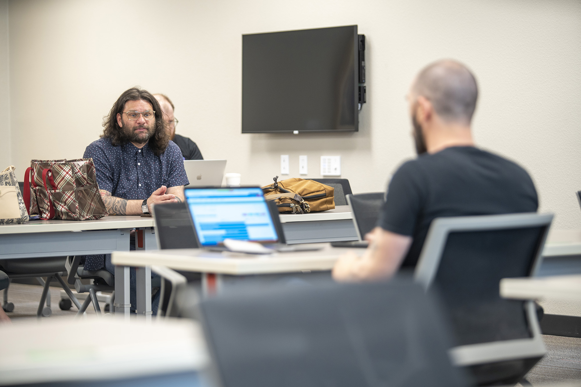 Two people look at each other from across a classroom.