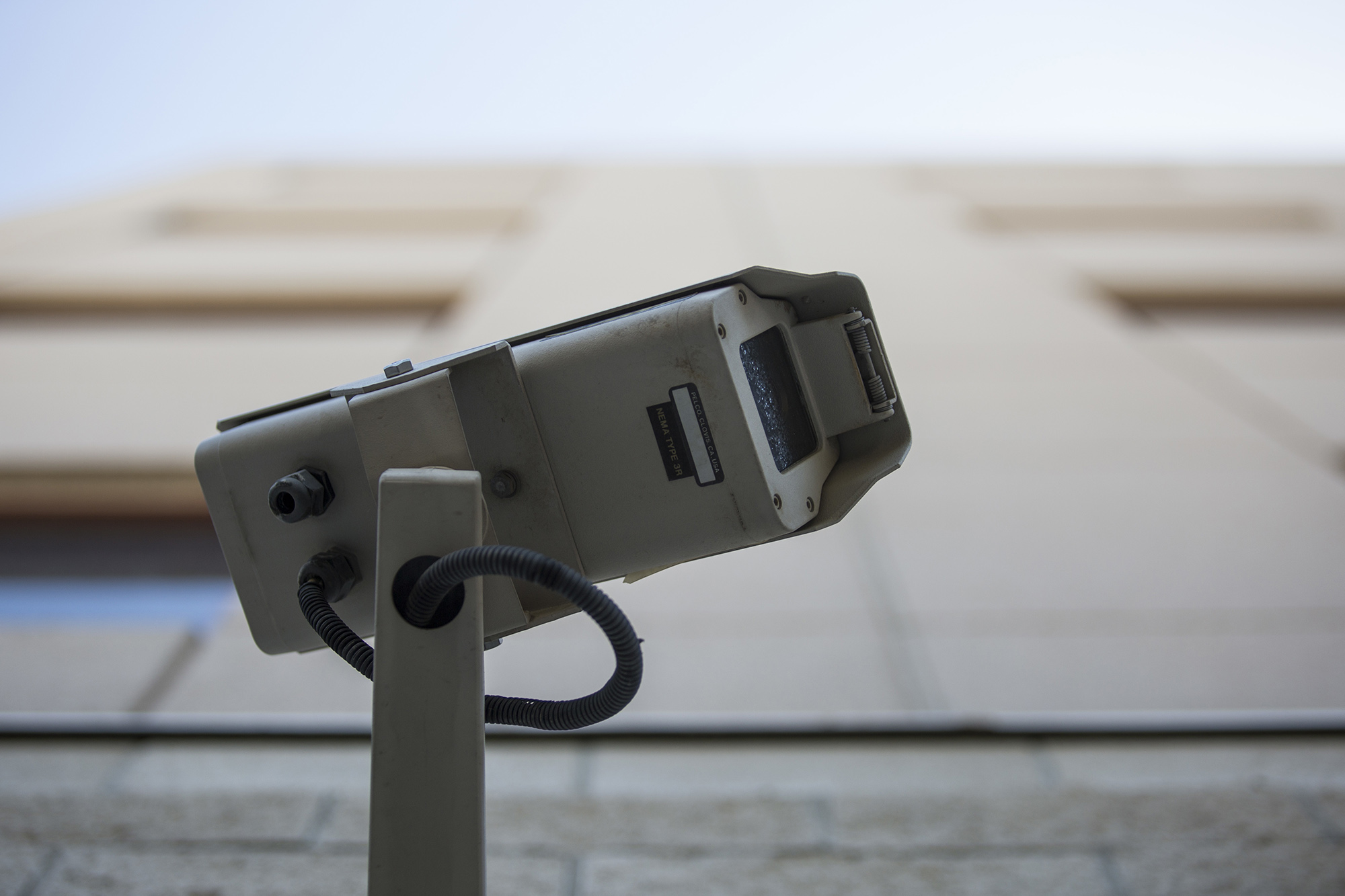 A security camera on the side of a U-N-L-V building.