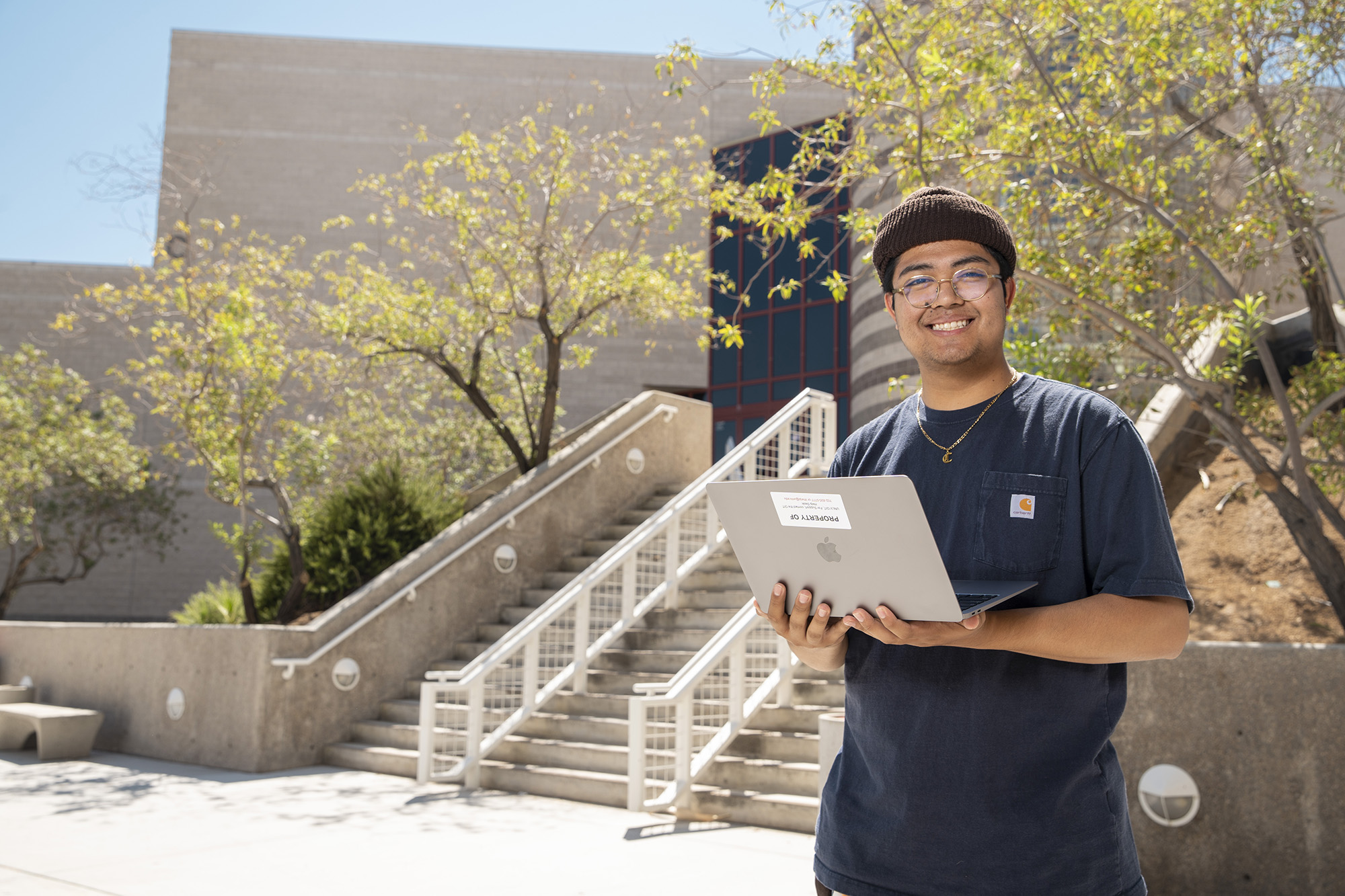 Student holding laptop computer outside as part of OIT laptop loan program.