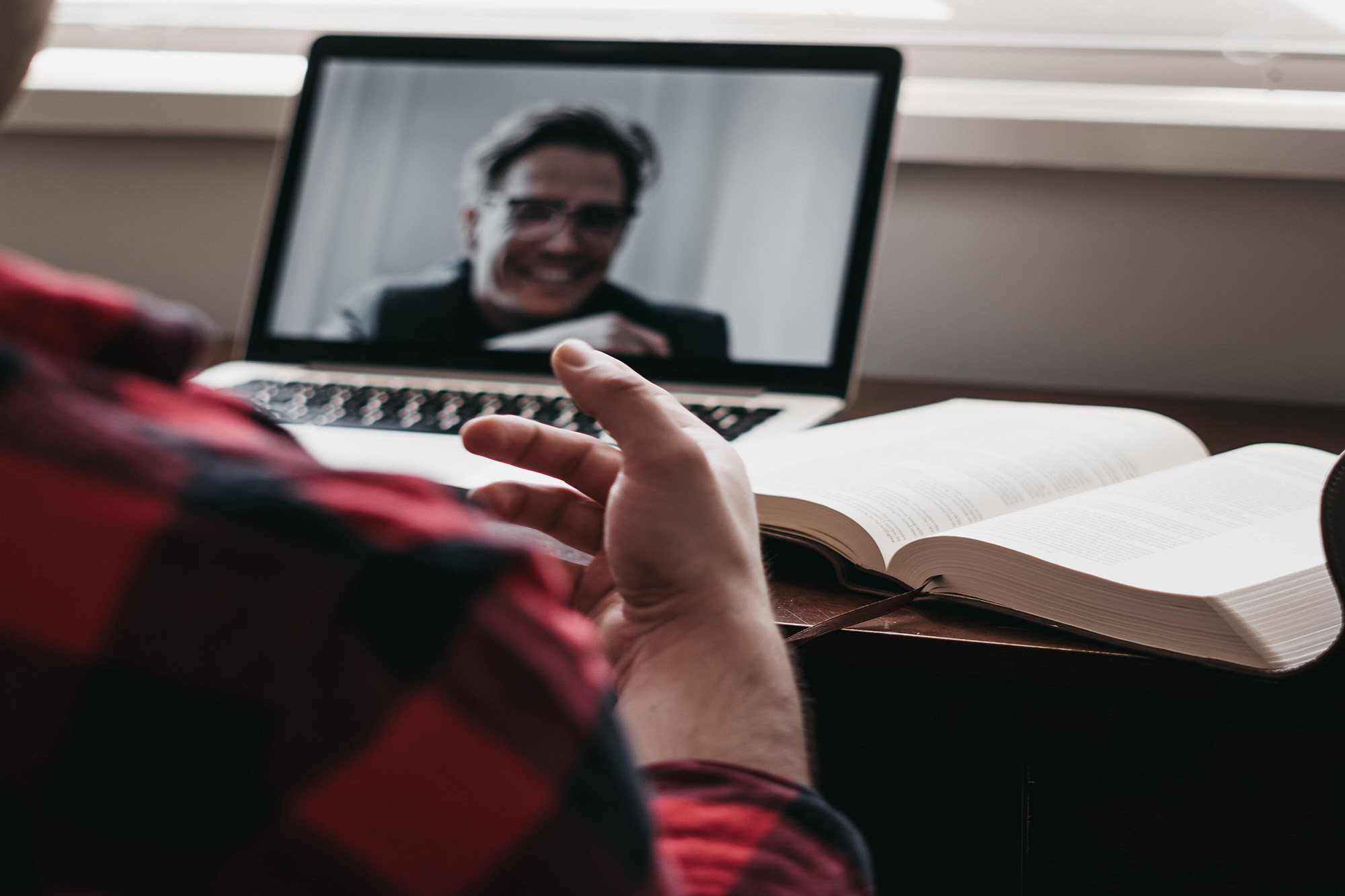 A laptop displaying a person in a video conference.