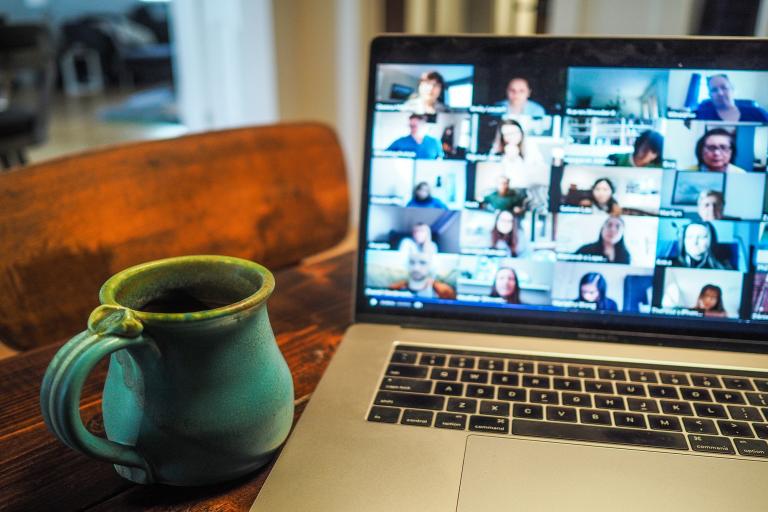 Macbook Pro displaying group of people in Zoom conference.