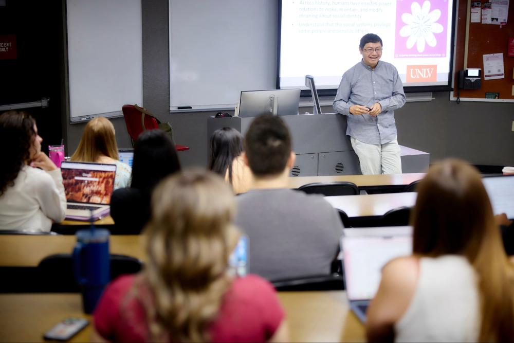 Person standing in front of classroom looking at students sitting at desks
