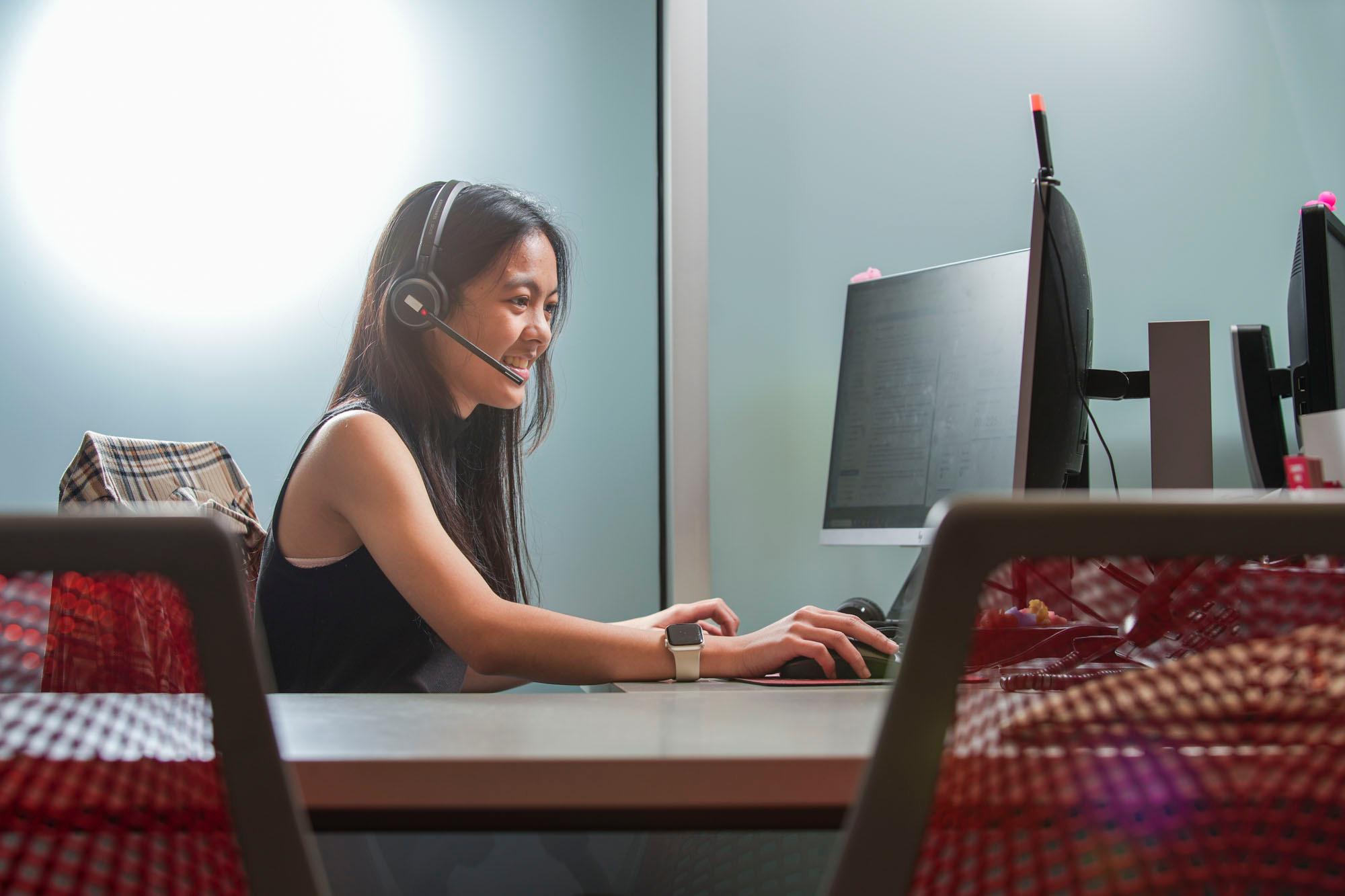 UNLV IT Help Desk employees assisting customers on the computer.