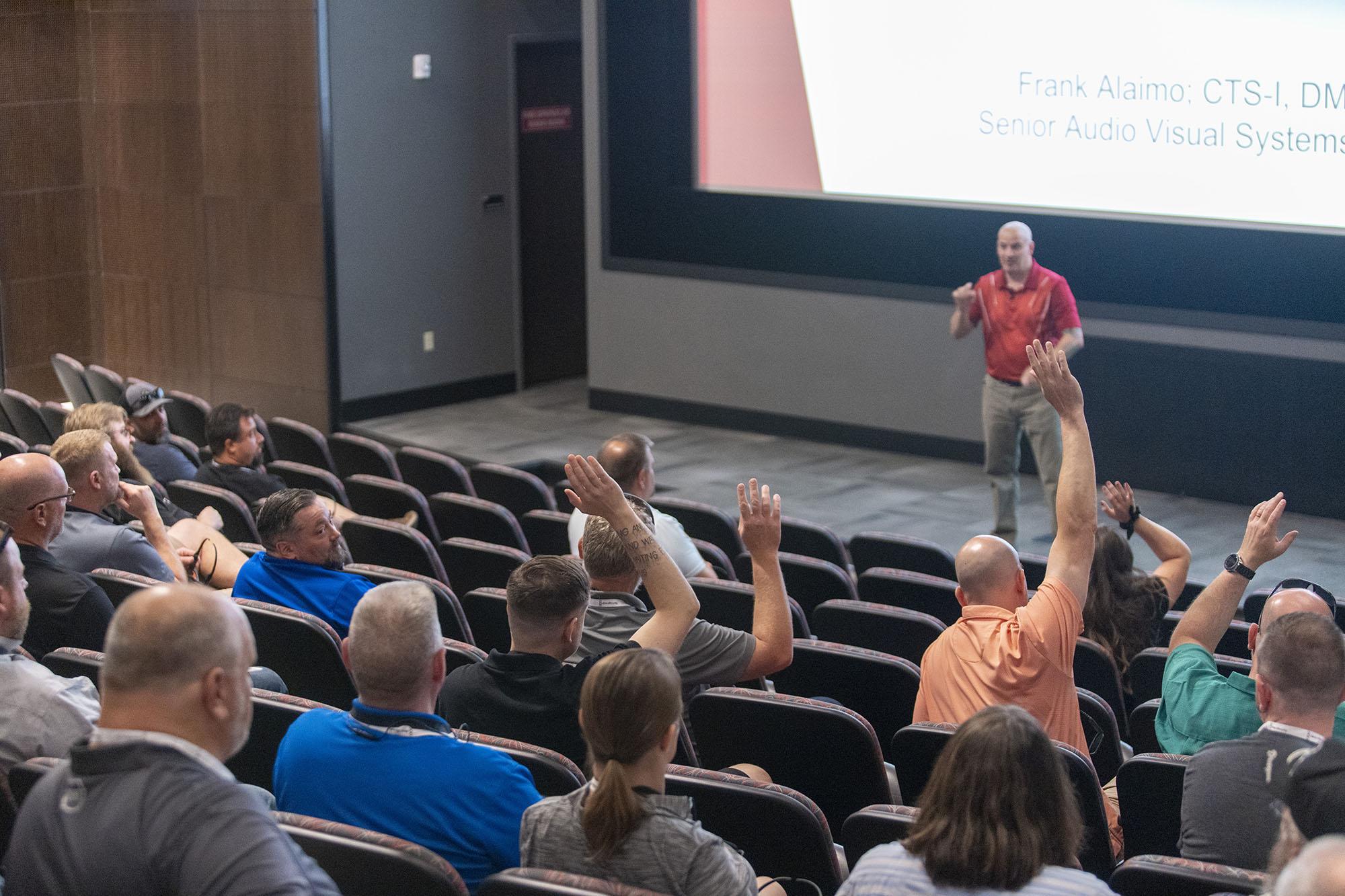 Audience members raising hands in FDH theater during InfoComm 2022