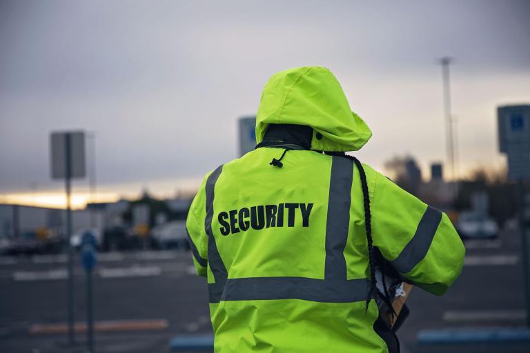 A person wearing a lime green security coat.