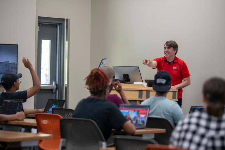 Instructor calling on a student with their hand raised. 