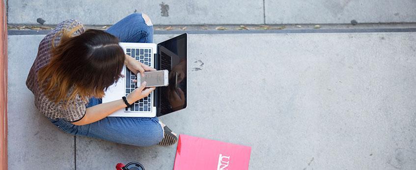 A female student peers at her smartphone.